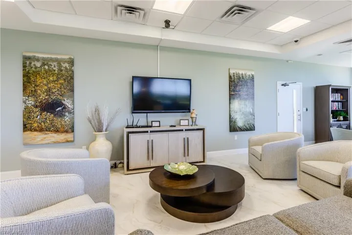 Tiled living room featuring a paneled ceiling and a tray ceiling