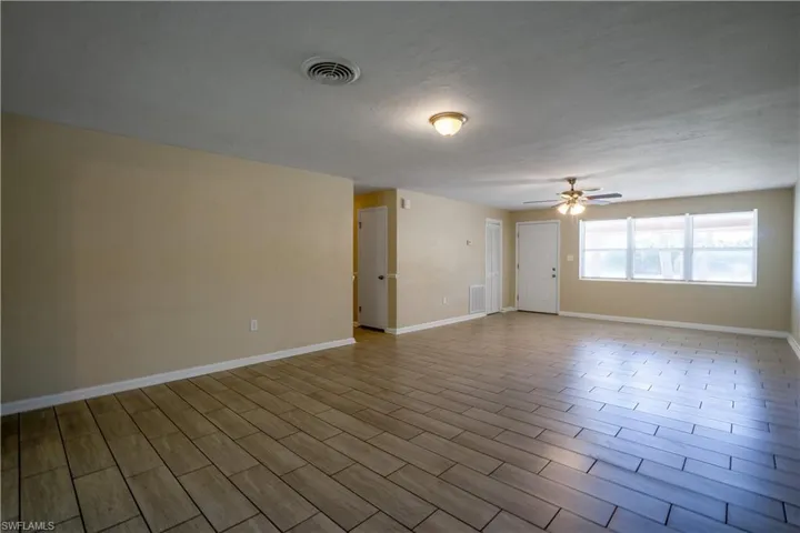 Spare room featuring wood finish floors, ceiling fan, and a textured ceiling
