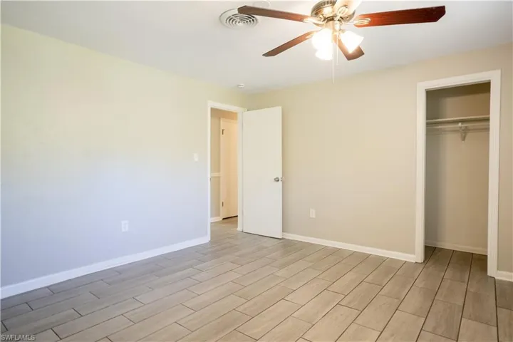 Unfurnished bedroom with wood tiled floors, a ceiling fan, and a closet