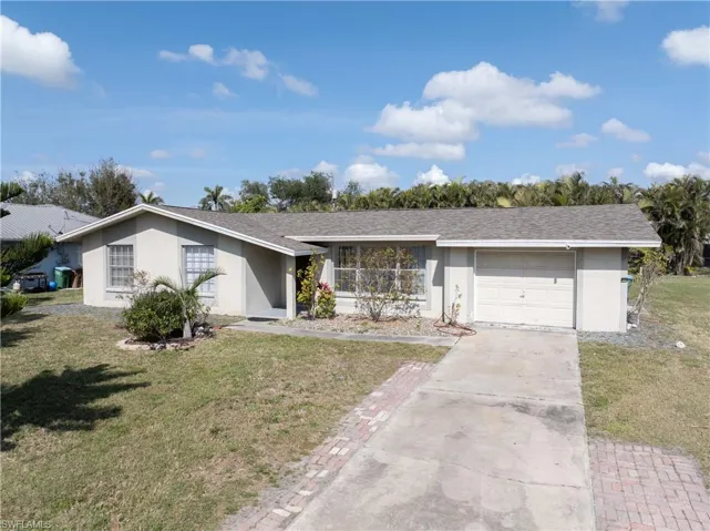 Ranch-style house with a garage and a front yard
