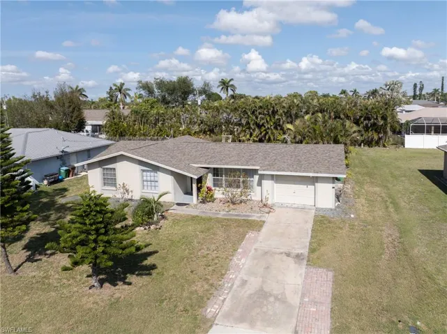 Ranch-style house featuring a garage and a front yard