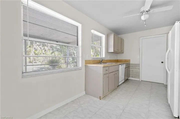 Kitchen featuring ceiling fan, sink, and white appliances