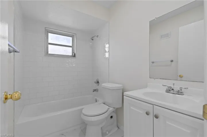 Full bathroom with vanity, toilet, and tiled shower / bath combo