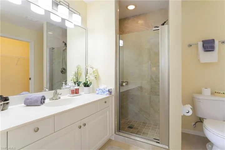 Bathroom featuring vanity, toilet, an enclosed shower, and tile patterned floors