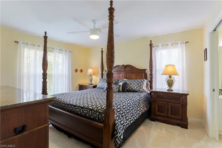 Bedroom with ceiling fan and light carpet
