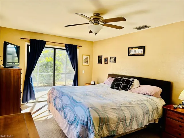 Carpeted bedroom featuring access to exterior and a ceiling fan