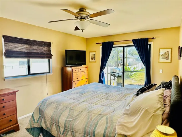 Bedroom featuring access to exterior, carpet, and a ceiling fan