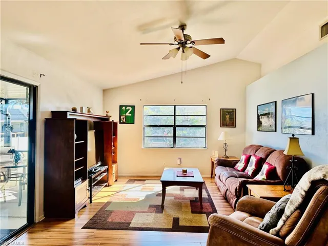 Living room featuring lofted ceiling and a ceiling fan,