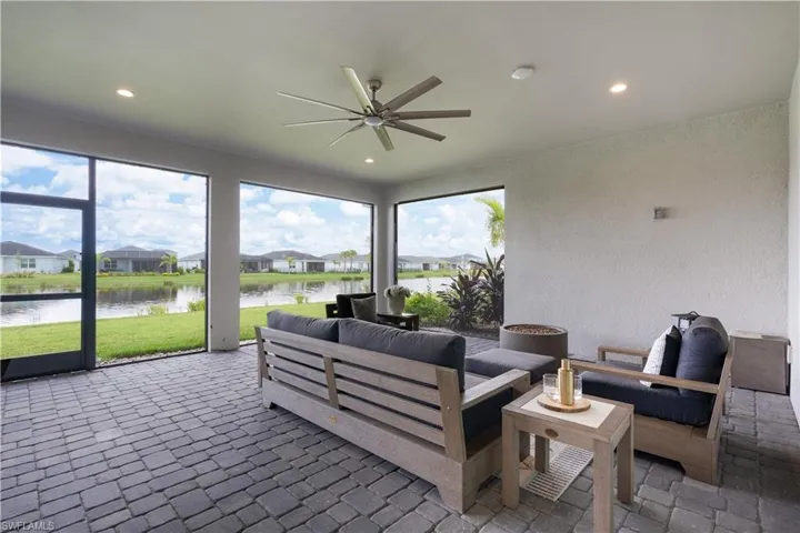 Sunroom featuring a residential view, a textured wall, a water view, and recessed lighting
