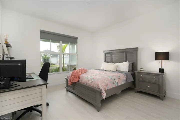 Bedroom featuring wood tiled floors and an office area