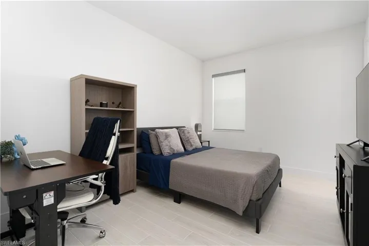 Bedroom with an office area and wood finish floors