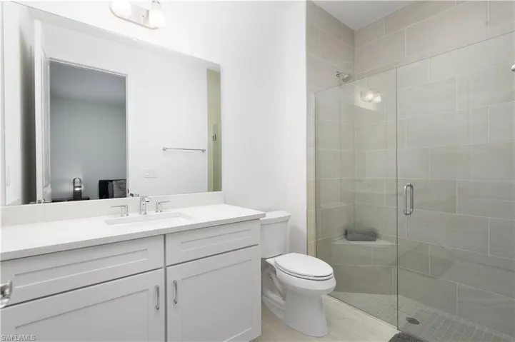 Bathroom with a stall shower, vanity, and light wood-style flooring