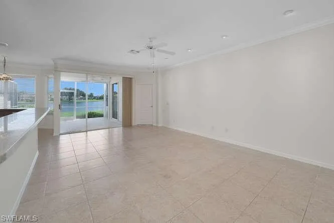 Tiled spare room with ornamental molding and ceiling fan