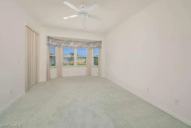 Carpeted empty room featuring ceiling fan
