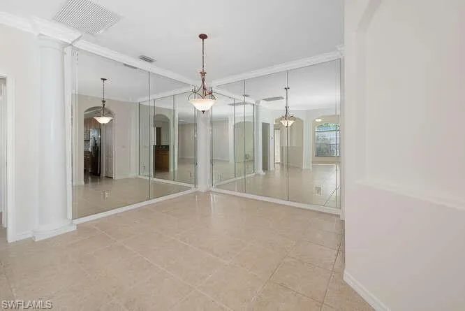 Spare room with light tile patterned flooring and ornate columns
