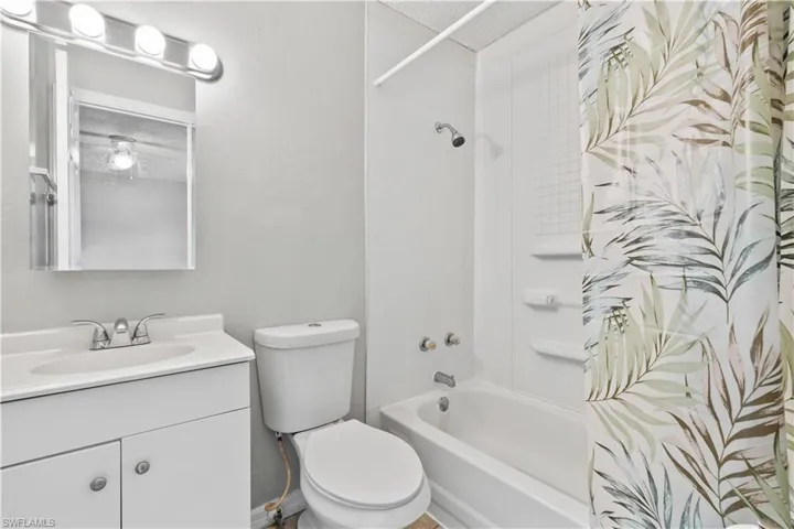 Full bath with shower / bath combo, vanity, and a textured ceiling