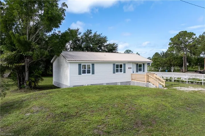Manufactured / mobile home with a metal roof and a wooden deck