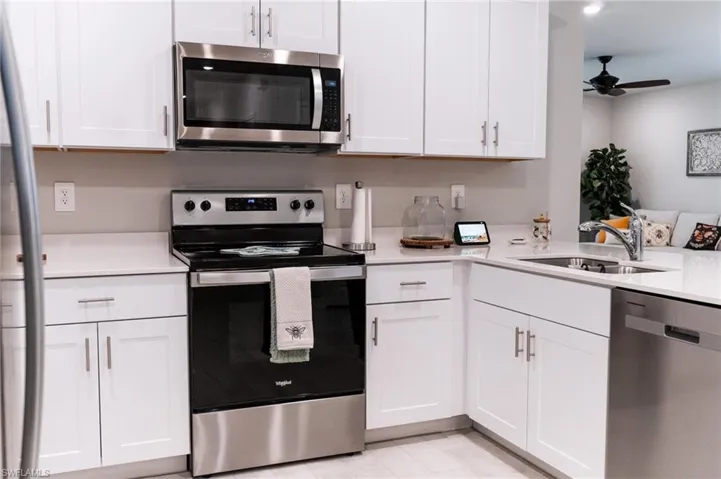Kitchen featuring sink, ceiling fan, stainless steel appliances, and white cabinets