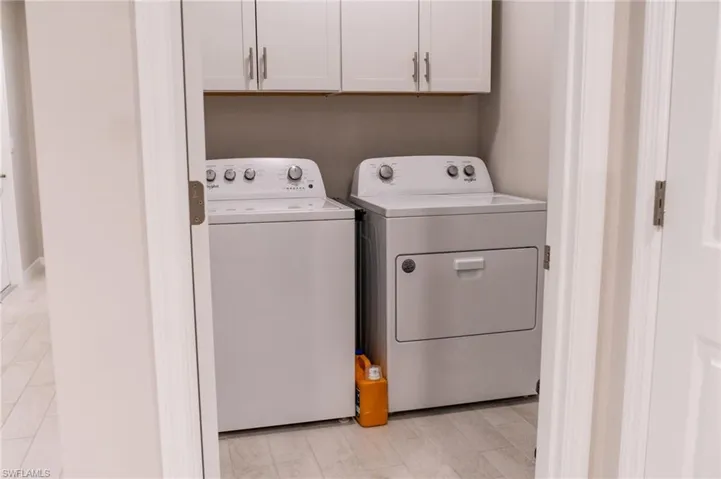 Laundry room with cabinets, light hardwood / wood-style floors, and washer and dryer