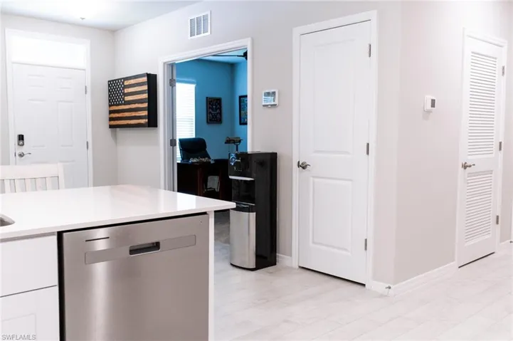 Kitchen with light wood-type flooring, dishwasher, and white cabinets