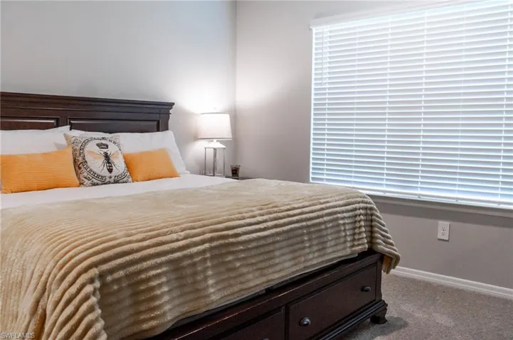 Carpeted bedroom with multiple windows