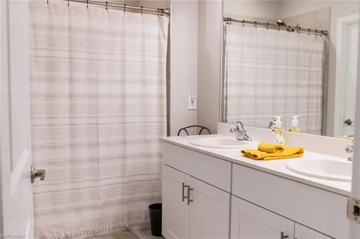 Bathroom featuring a shower with curtain and vanity