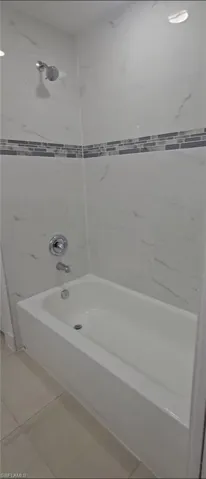Bathroom with  shower combination and light tile patterned flooring