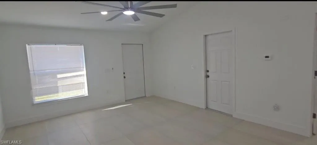 Foyer featuring ceiling fan and vaulted ceiling