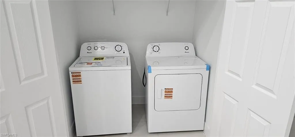 Laundry area featuring washer and dryer and light tile patterned floors