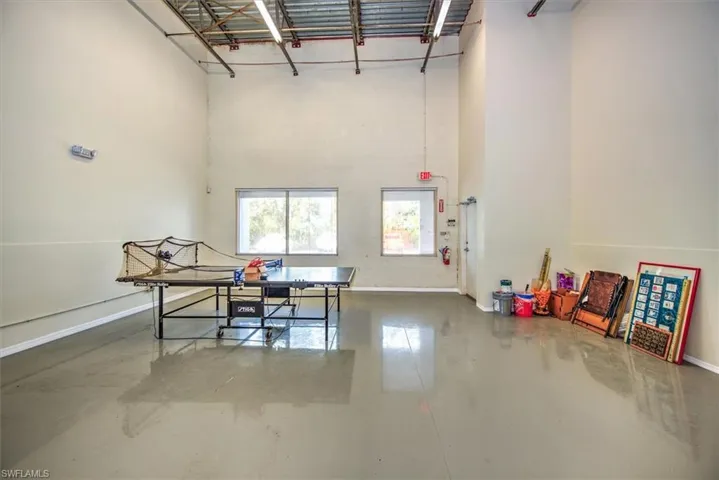 Office area with concrete flooring, a high ceiling, and baseboards