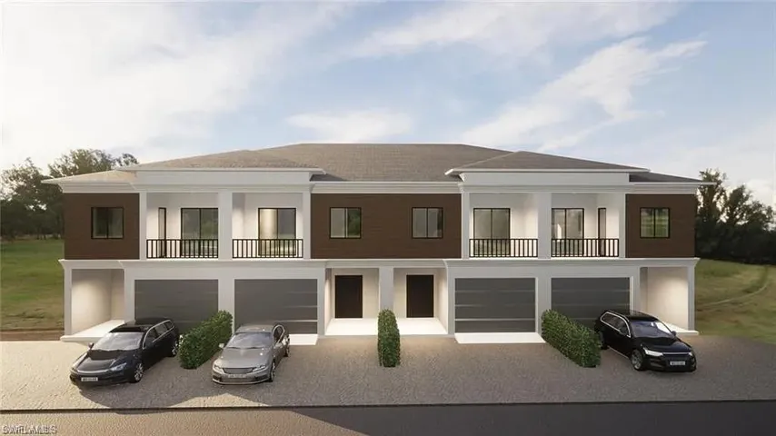Rear view of property with a balcony, an attached garage, and driveway