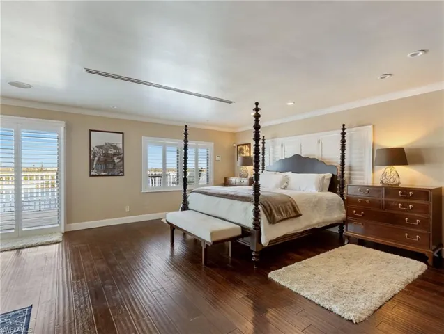 Primary Bedroom with hardwood flooring, sliders to private balcony