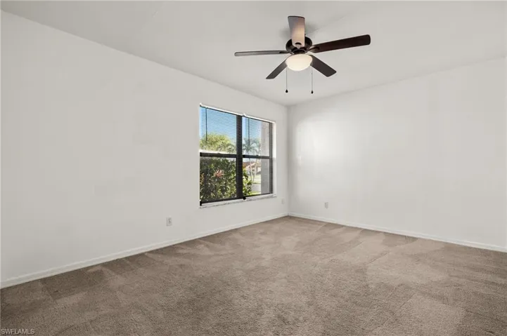 Spare room featuring carpet flooring and ceiling fan