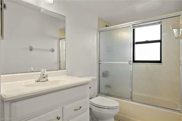 Full bath with vanity and bath / shower combo with glass door