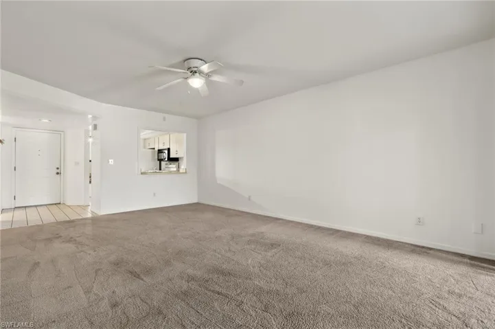 Unfurnished living room with a ceiling fan and light carpet
