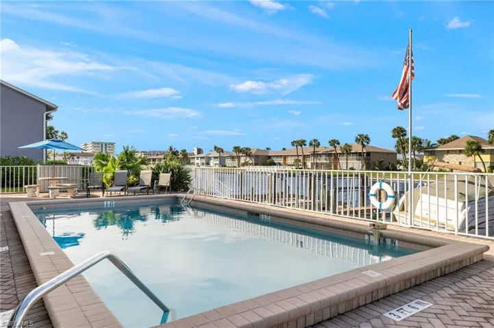 Community pool with a patio area and a residential view