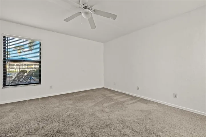 Carpeted empty room with baseboards and ceiling fan