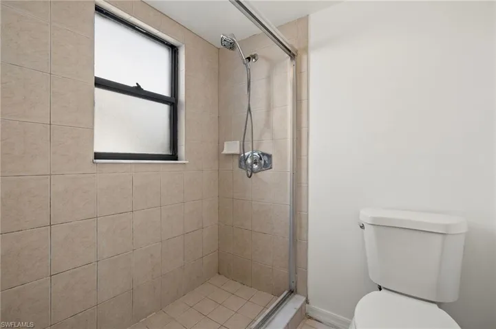 Bathroom with a shower stall and toilet