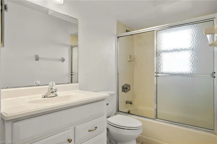 Full bathroom featuring vanity and bath / shower combo with glass door