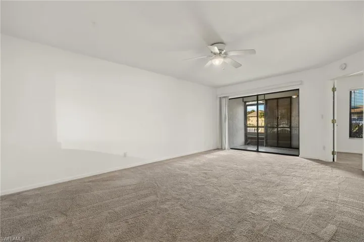 Unfurnished room featuring a ceiling fan and carpet