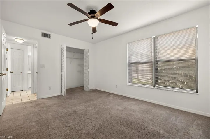 Unfurnished bedroom featuring carpet flooring, ceiling fan, and a closet