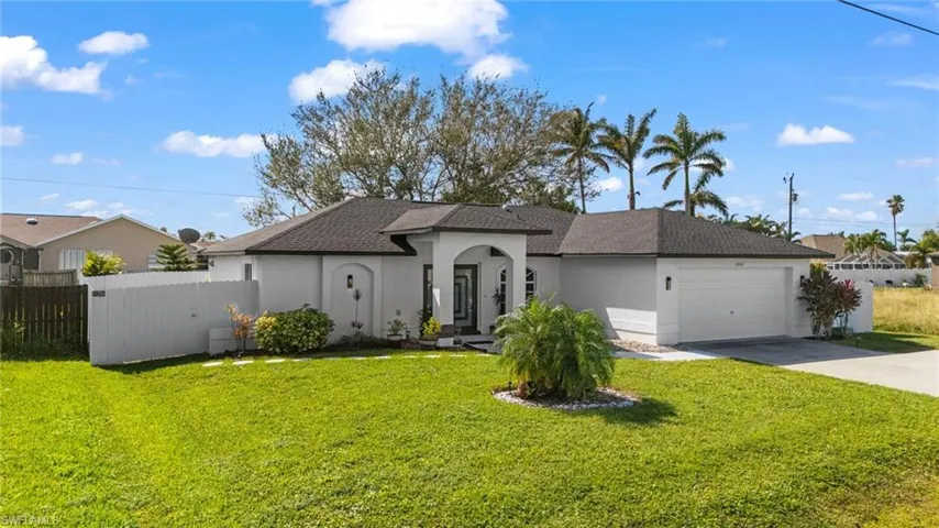 View of front of home with a garage and a front lawn