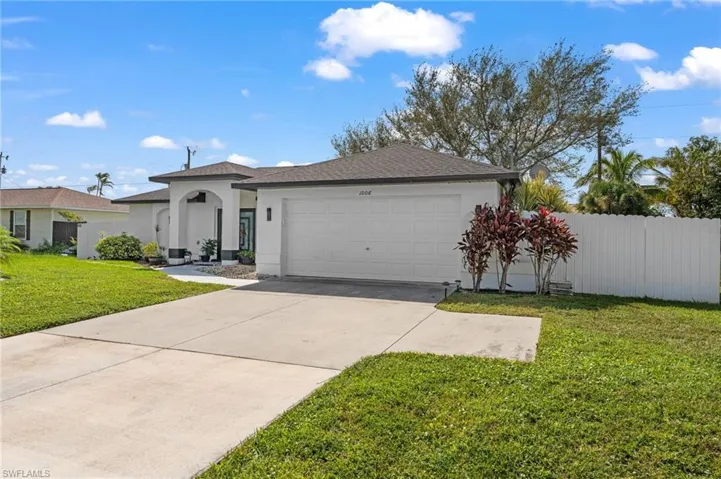 View of front of home with a garage and a front yard