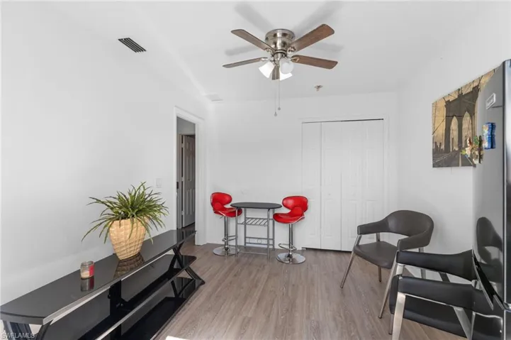 Living area with hardwood / wood-style floors and ceiling fan