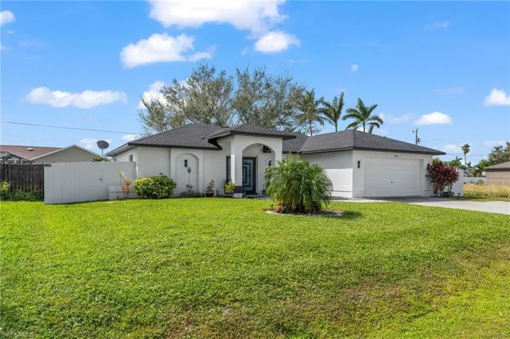 Single story home featuring a garage and a front yard