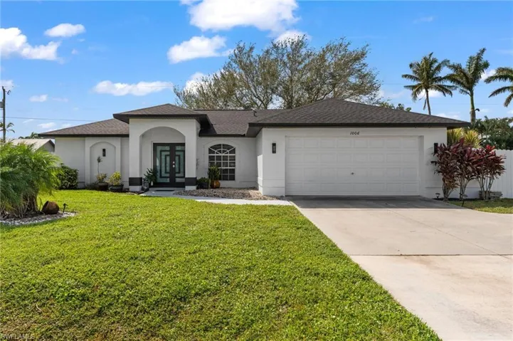 View of front of home with a garage and a front lawn