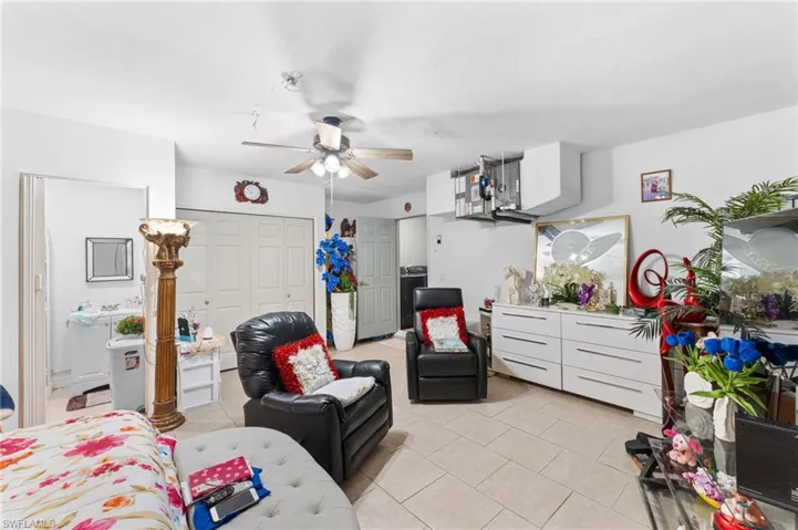 Living room with light tile patterned flooring and ceiling fan