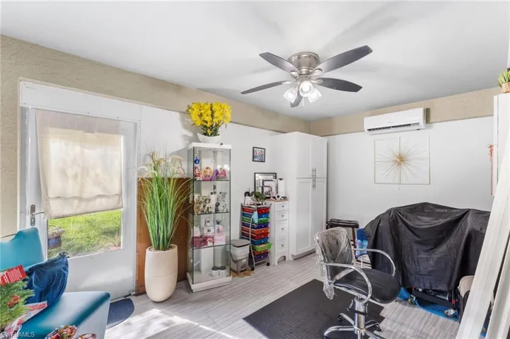 Home office featuring a wall mounted AC and ceiling fan