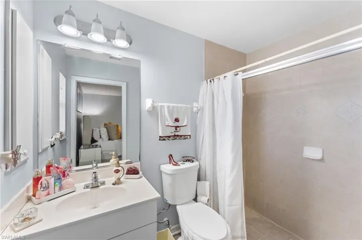 Bathroom featuring toilet, vanity, and a shower with shower curtain
