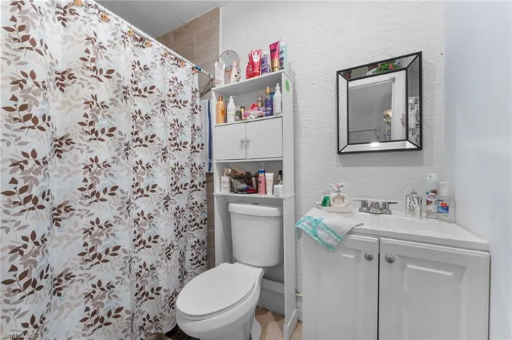 Bathroom featuring toilet, vanity, and a shower with shower curtain